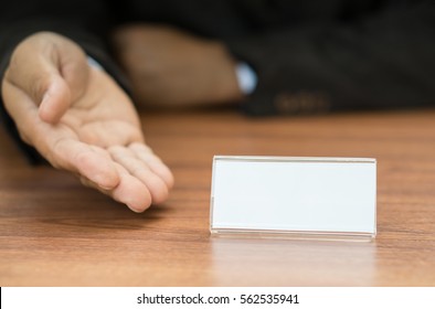 businessman show empty white tag on desk