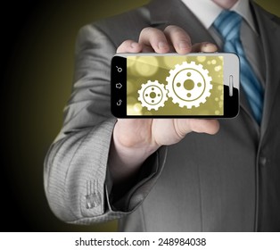 businessman show gear on smartphone to success concept - Shutterstock ID 248984038