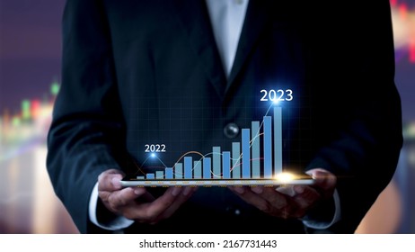 Businessman Show Stock Market Bar Chart Grow Up To Target. Business Finance Concept. Businessman's Hands Show Success Graph, Stocks Grow Every Year And Set Goals For 2023