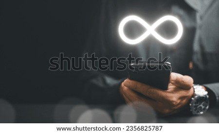Businessman showcasing smartphone with infinity symbol, symbolizing unlimited connection in data technology, future unlimited. Infinite power, energy, internet information. technology infinity data