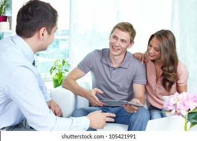 Businessman showing a business plan or insurance program on the screen of the pad to the young people