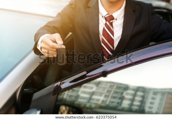 businessman showing a car key - car sale &
rental business
concept