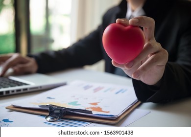 Businessman Showing Compassion Holding Red Heart Onto His Chest, Service Mind Business Concept
