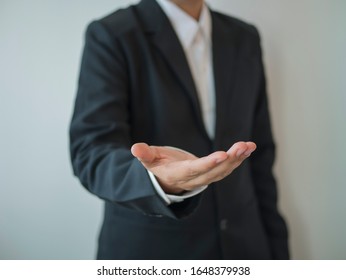 Businessman showing empty hand wearing deep black suit