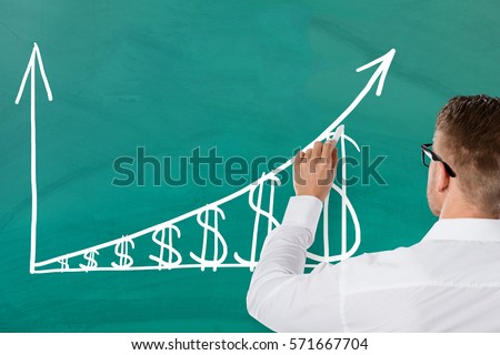 Businessman Showing Inflation Concept With Increasing Dollar Graph On Green Blackboard. Salary Growth Concept