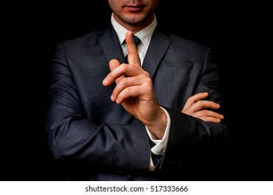 Businessman showing one finger, making silence gesture. Shh!!!