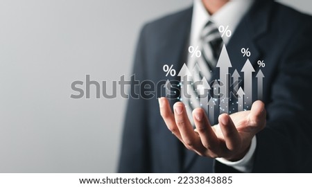 Businessman showing percentage icons and up arrow icons with graph indicators. Concept of financial interest rates and mortgage rates.  Interest Rates Stocks Finance Ratings Mortgage Rates.