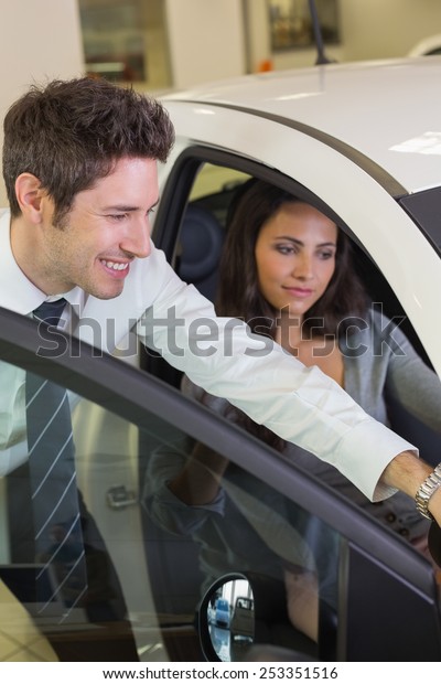 Businessman showing something to his customer at\
new car showroom