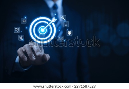 Businessman showing target arrow virtual digital technology icon on board, business investment concept, objectives and goals Marketing strategies and goals for success