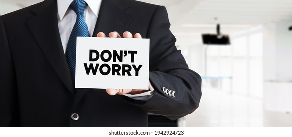 Businessman Shows A Business Card With The Word Don't Worry. Overcoming Stress And Anxiety In Business.

