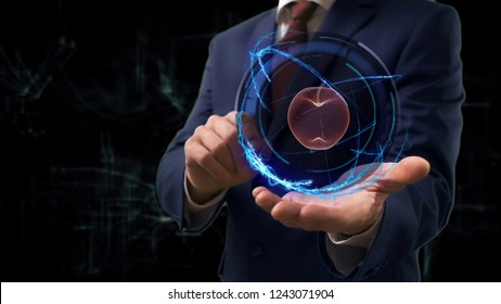 Businessman Shows Concept Hologram 3d Apple On His Hand. Man In Business Suit With Future Technology Screen And Modern Cosmic Background