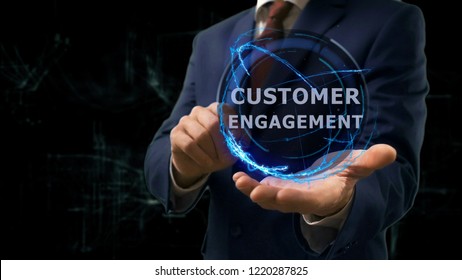 Businessman shows concept hologram Customer engagement on his hand. Man in business suit with future technology screen and modern cosmic background