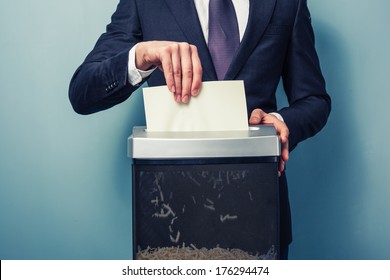 A Businessman is shredding important documents