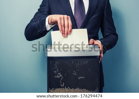 A Businessman is shredding important documents