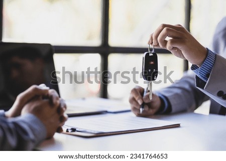 Businessman signing car purchase, lease contract agreement with car salesman, car insurance.