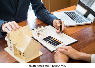 Businessman signs contract behind home architectural model
Discussion with a real estate agent rental company staff 
at the office property appraisal and valuation concept - Powered by Shutterstock