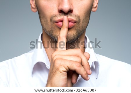 Businessman silent quiet gesture with finger