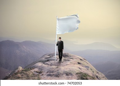 Businessman Sinking A Flag On The Top Of A Mountain