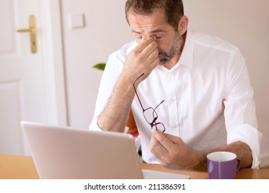 businessman sitting at desk and looking stressed 
