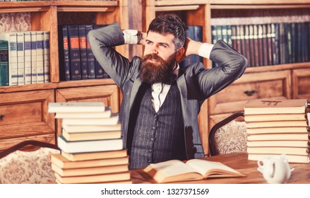 Businessman sitting at desk in office being busy studying books