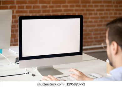 Businessman Sitting At Desk In Office Working Using Laptop With White Mockup Blank Screen Close Up View Over Shoulder. Worker Chatting Typing Email Message Business Letter On Pc Looking On Desktop