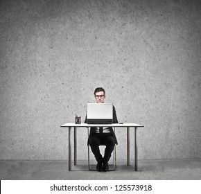 Businessman Sitting At A Desk Using A Laptop