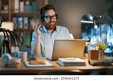 Video Hombre de negocios sentado en su escritorio y teniendo una llamada, lleva un auricular y habla, negocio y concepto de comunicación