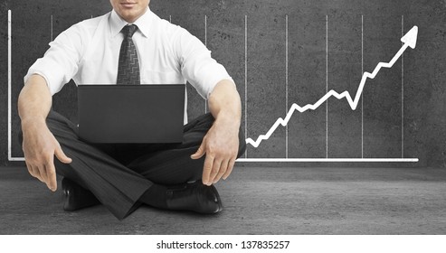 businessman sitting in lotus position and drawing arrow on wall - Powered by Shutterstock