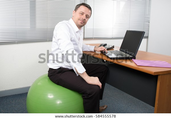 Businessman Sitting On Exercise Ball Desk Stock Photo Edit Now