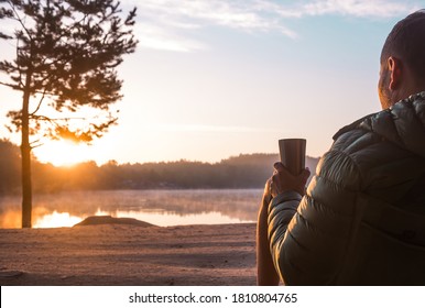 Businessman sitting on a lake with cup of coffee. Morning and sunrise on beautiful nature. Lake and mountains. happy man. inspiration concept, enjoy life. Calm and peace.