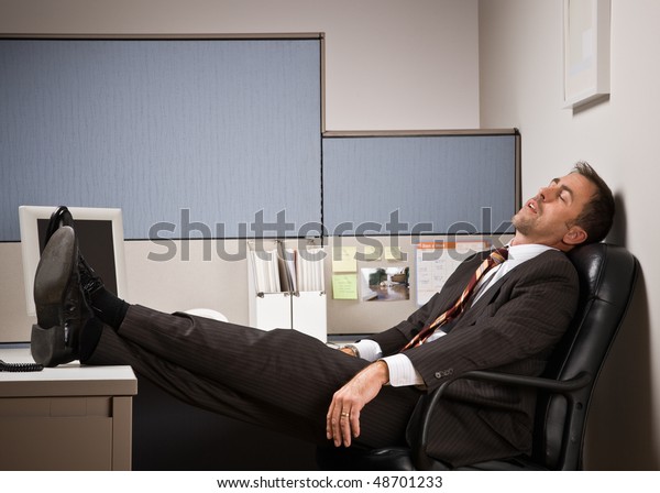 机の上で足を上げて寝る実業家 の写真素材 今すぐ編集