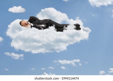 Businessman sleeping on clouds and blue sky - Powered by Shutterstock