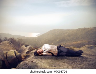 Businessman Sleeping On A Rock