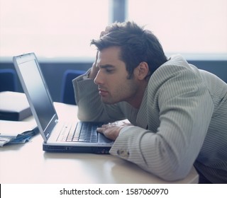 Businessman slouching in front of laptop
