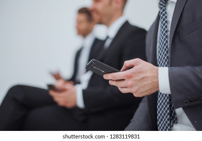 businessman with a smartphone sitting in the office reception