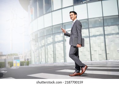 Businessman with smartphone walking against street blurred building background, Fashion business photo of beautiful girl in casual suite with smart phone. - Shutterstock ID 2187700159
