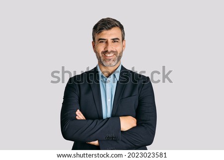 Businessman smiling with arms crossed on white background	