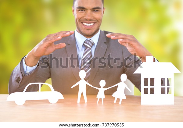 Businessman smiling behind
car, family and house illustration against detail shot of bright
green leaves