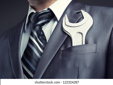 Businessman With Spanner In Suit Pocket