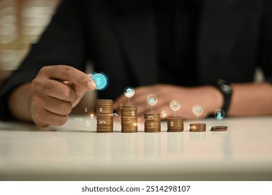 Businessman stacking coins in ascending order representing financial growth and savings goals - Powered by Shutterstock