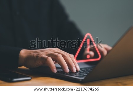 Businessman or it staff , programmer, developer using computer laptop with triangle caution warning sign for notification error and maintenance concept.