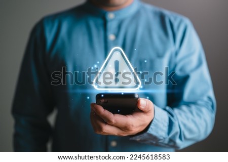 Businessman or it staff , programmer, developer using smart phone with triangle caution warning sign for notification error and maintenance concept. remote work by phone connection application.