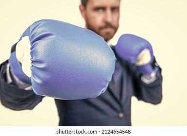 Businessman stand in fighting position wearing blue boxing gloves selective focus, punching - Powered by Shutterstock