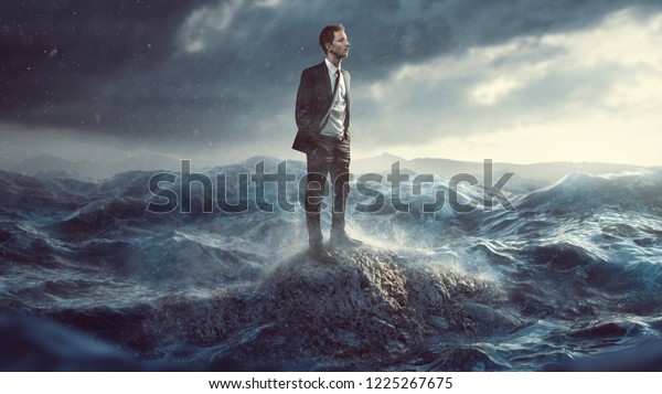Businessman standig on a\
rock in the surf