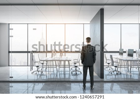 Businessman standing in bright office interior. Boss and executive concept.