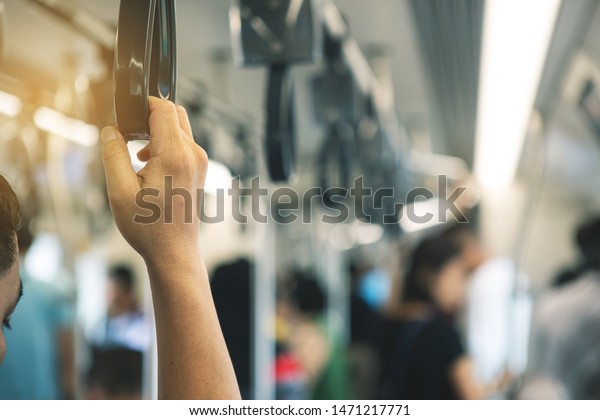 Businessman standing and holding handle on the\
skytrain bts go to work in the\
morning.