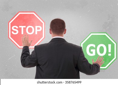 Businessman Standing And Holding A Stop Sign And Go Sign