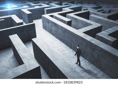 Businessman standing in middle of a concrete  labyrinth. Business and challenge concept. - Shutterstock ID 1810839823