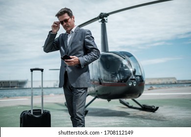 Businessman standing near private helicopter - Shutterstock ID 1708112149