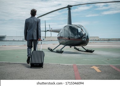 Businessman standing near private helicopter - Shutterstock ID 1715346094